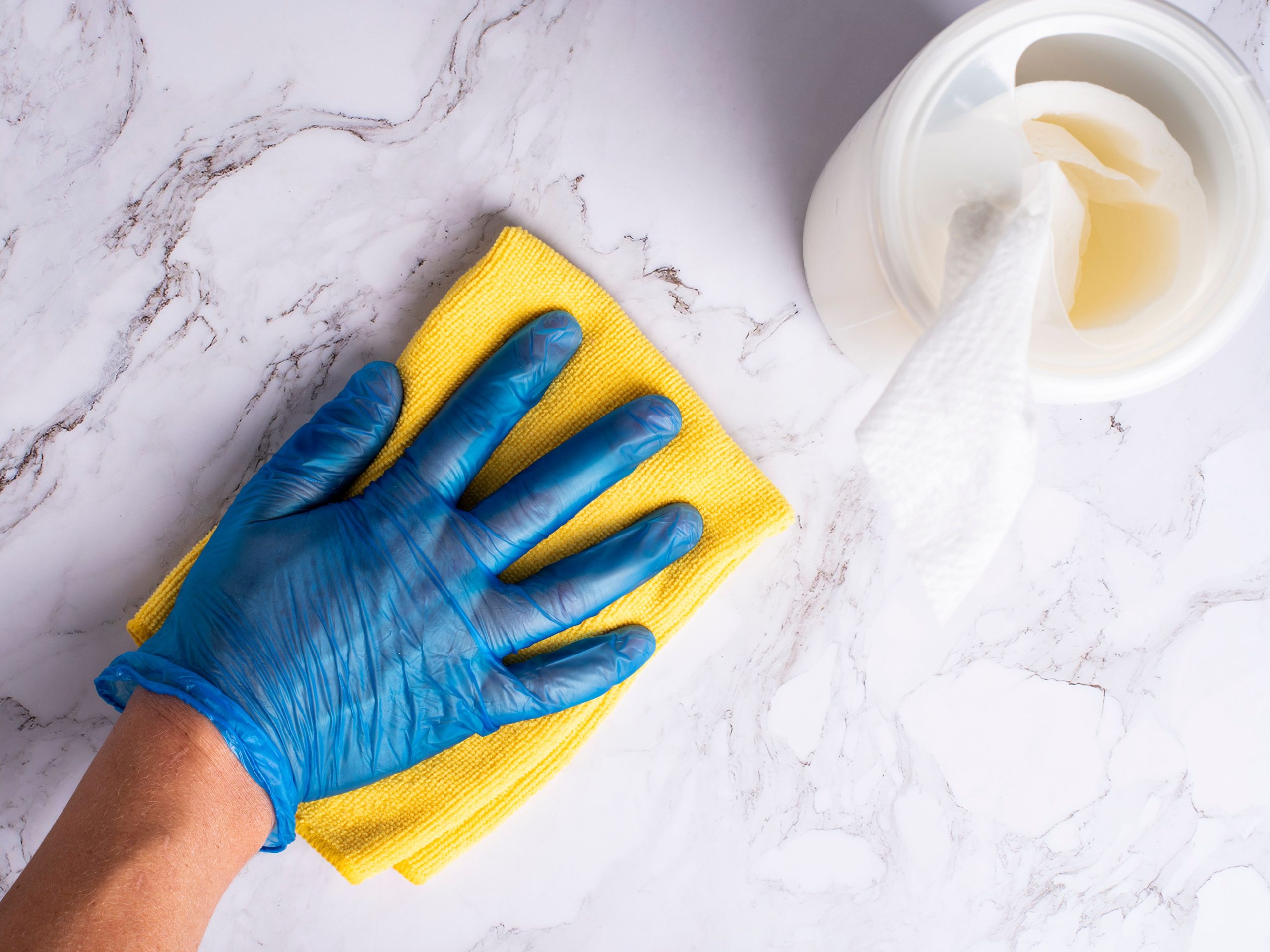 Book a cleaner in West London: a marble kitchen worktop wiped down with a blue cloth